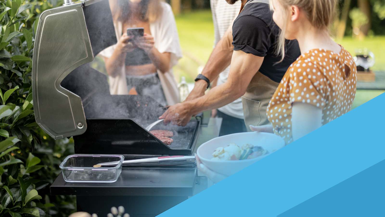 People grilling outdoors with a focus on the grill and one person using a smartphone.
